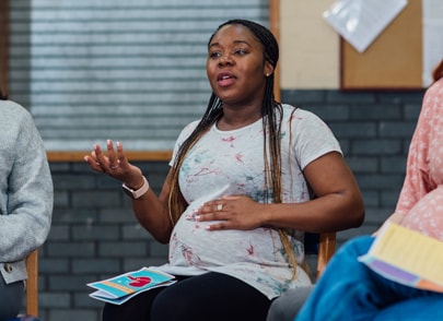 Pregnant woman talking in group environment