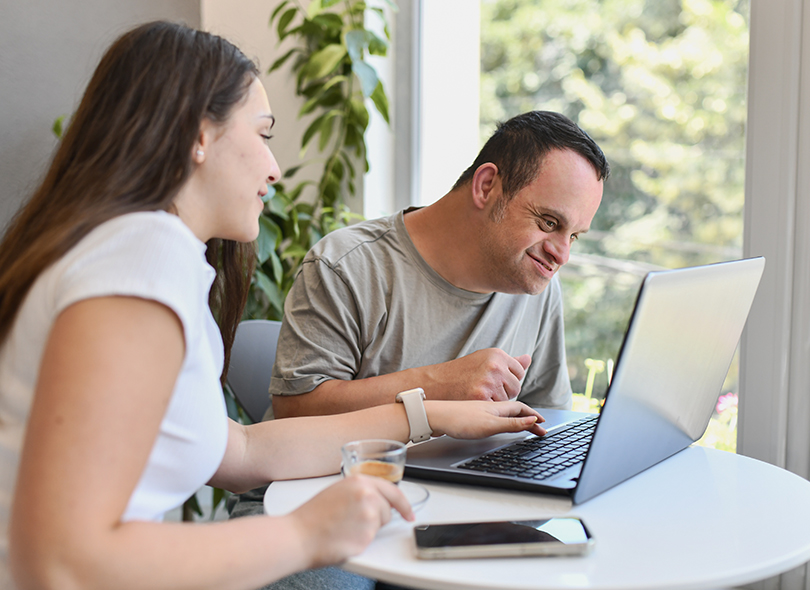 Man and women both working in an office environment with computers 
