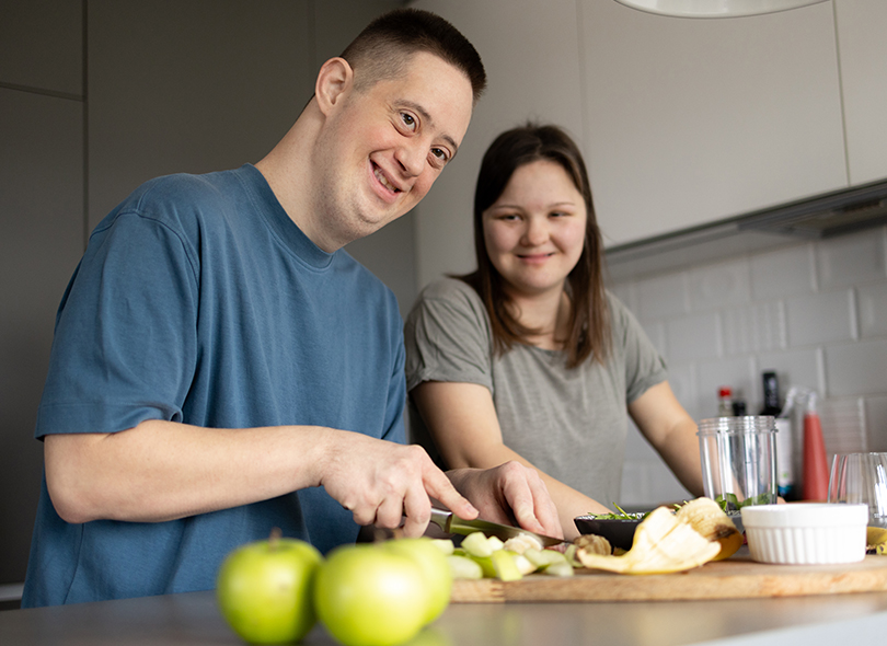 Man and woman in kitchen cooking together 