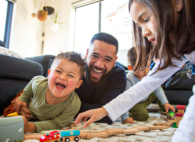 Dad playing trains with son and daughter 