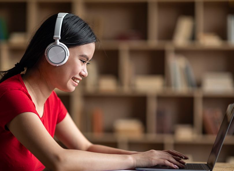 Girl with headphones on computer working 