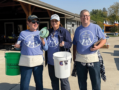 Three people with buckets