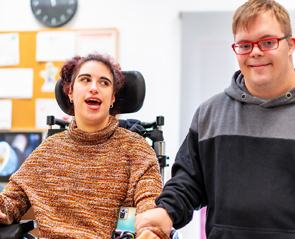 Photo of two young adults smiling in school environment