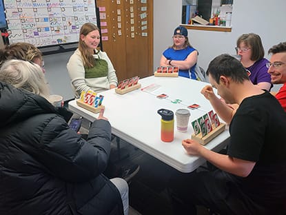 Group of people sitting around table playing games