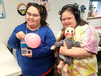 Two people with balloons and dolls