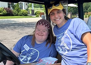 Photo of two adults in a golf cart