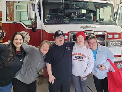 Five people in front of fire truck