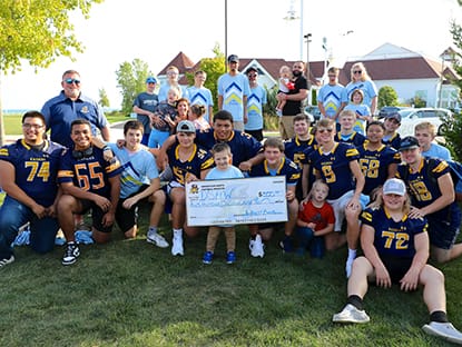 Group of people smiling holding check